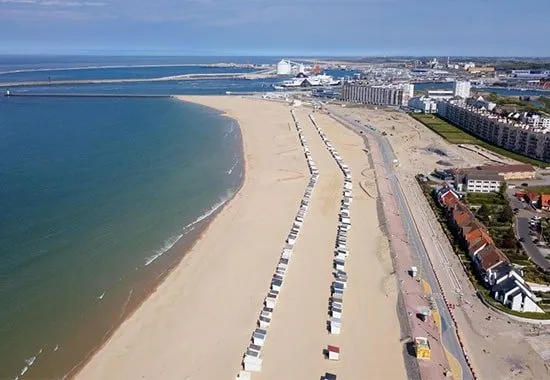 Het strand van Calais, met zijn strandhuisjes en het belfort in de verte