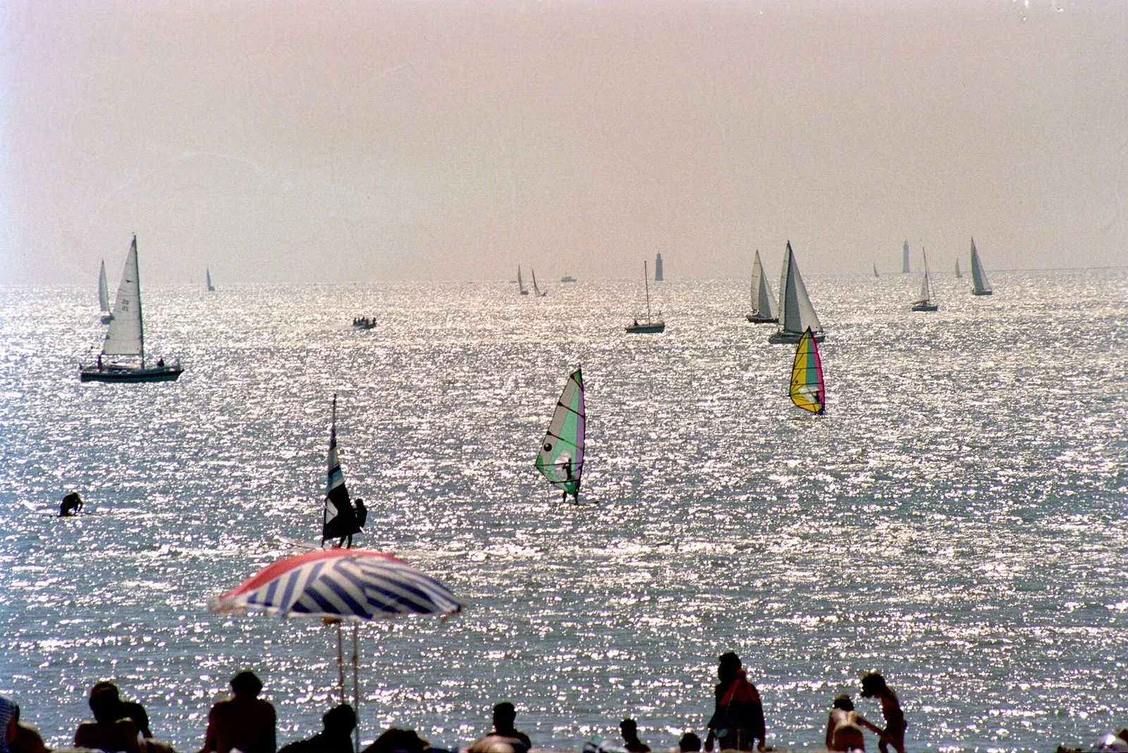 Sails out at sea, seen from the beach