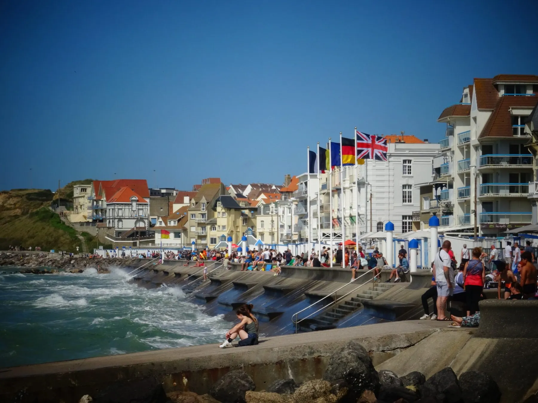 La digue de Wimereux, les vagues sur les enrochements et les drapeaux du front de mer