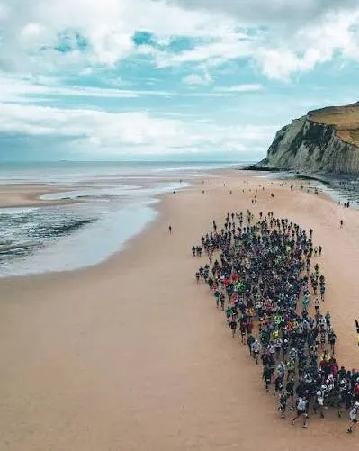 Het peloton van de trail gezien vanuit de lucht, op het zand bij laag water